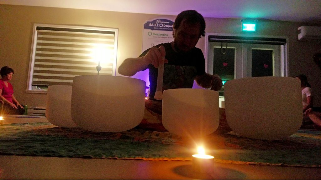 Lors de la prestation du bain de son, Charles Ostiguy joue avec les différents bols de cristal de quartz.